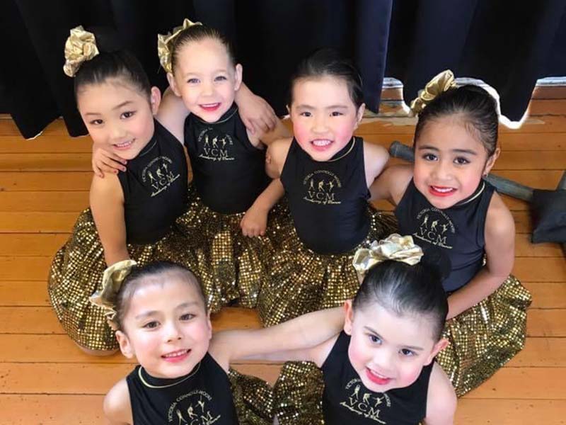 VCM Academy beginner dance classess students sit together in cute sequinned uniforms